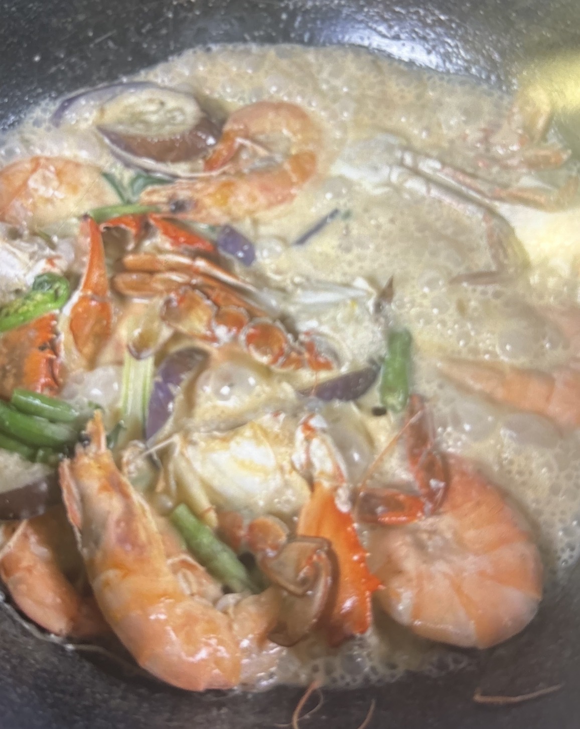 Shrimp with coconut milk and squash simmering in a pan